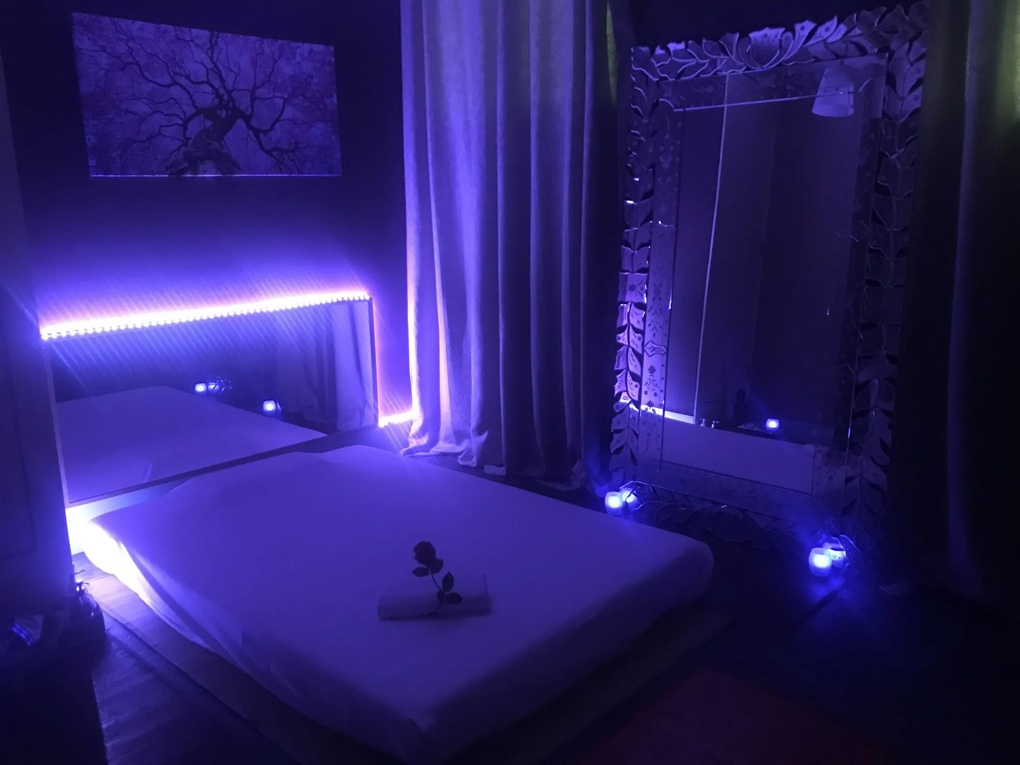 Luz violeta, un gran espejo de marco tallado y cortinas que envuelven la sala.
